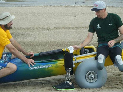 Getting into adaptive kayak on the beach